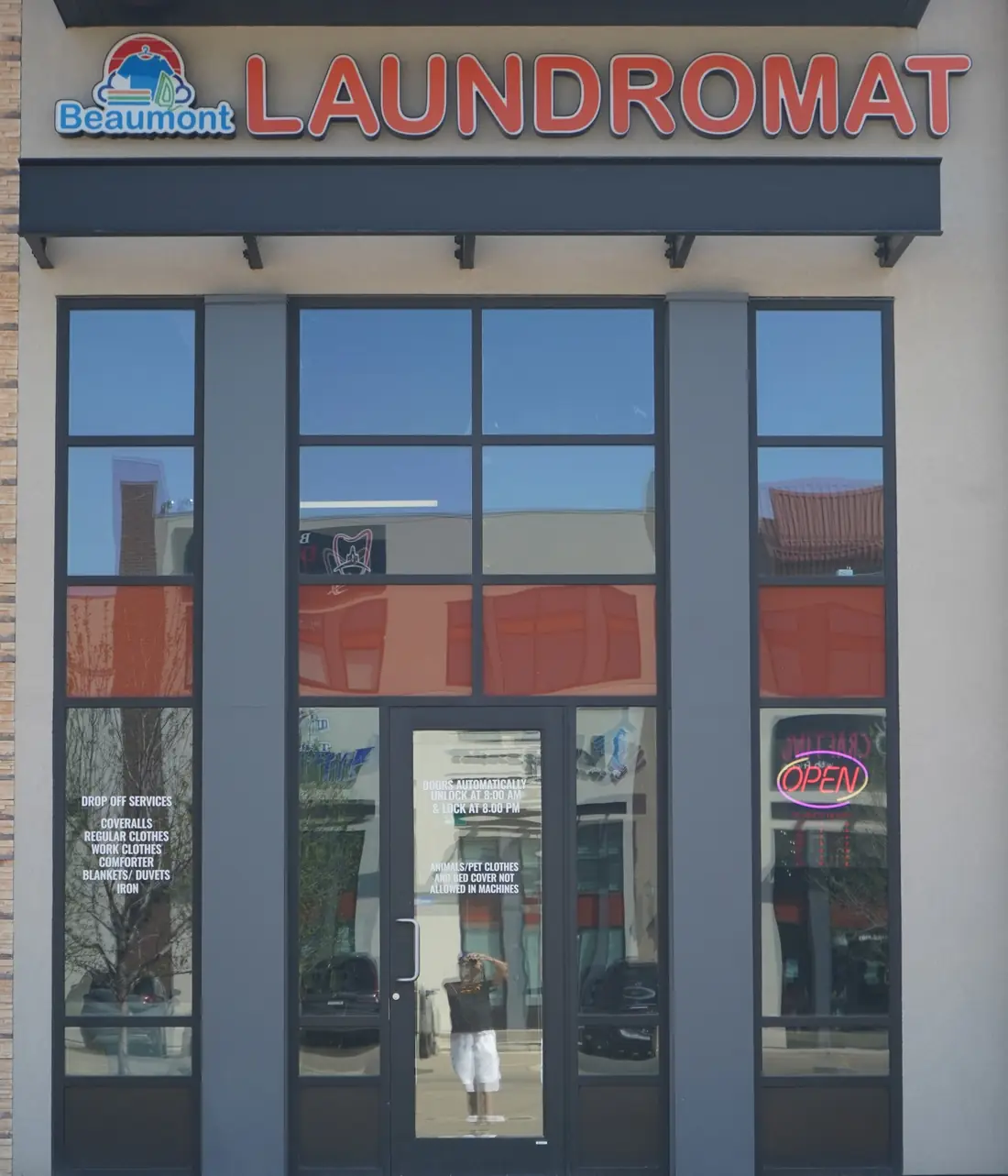 The Beaumont Laundromat storefront on Magasin Avenue, with the logo sign above tall windows listing drop-off services